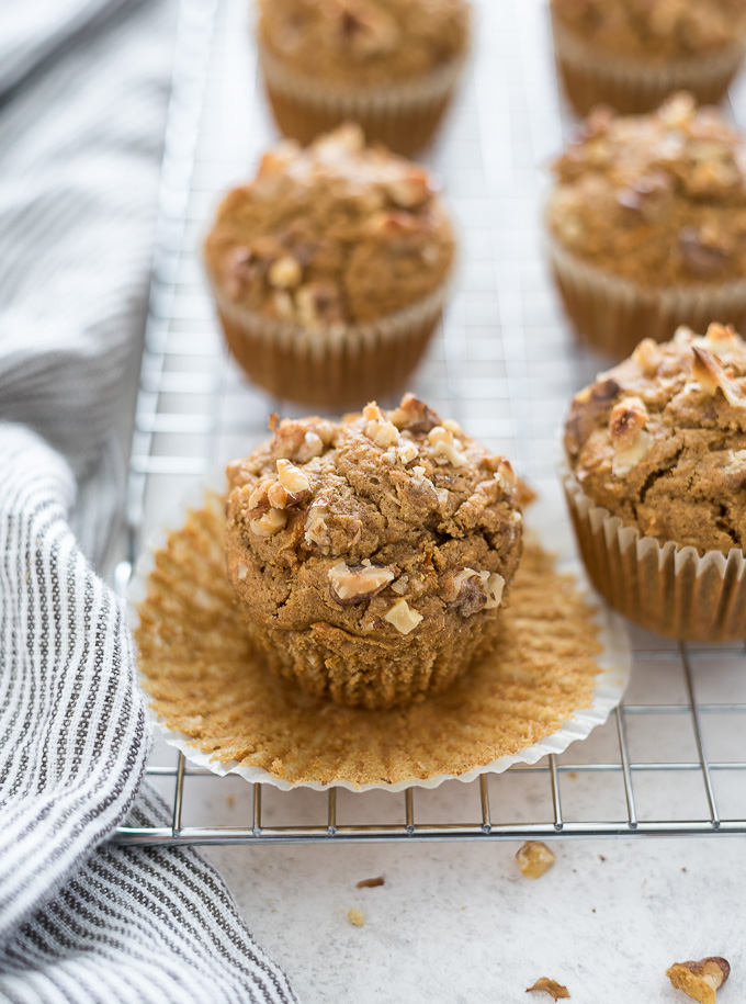 Healthy carrot cake muffins on a wire rack with paper liner removed