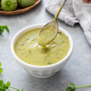 Homemade green enchilada sauce pouring from a spoon