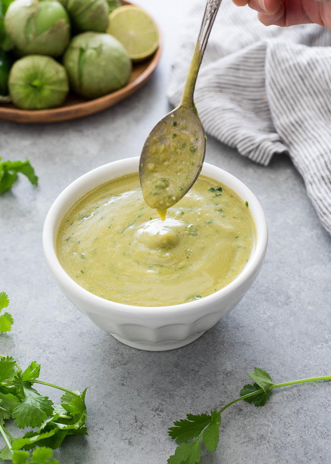 Green enchilada sauce drizzling into a bowl