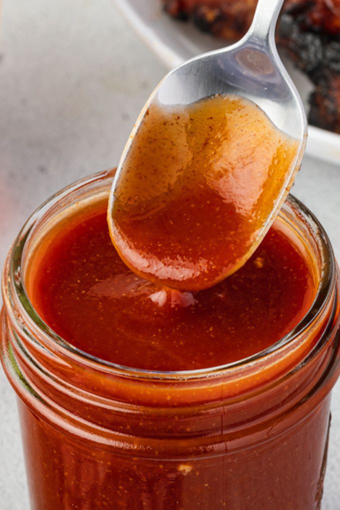 smoky bourbon bbq sauce drizzling from a spoon