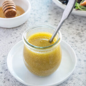 Honey mustard dressing in jar with a spoon