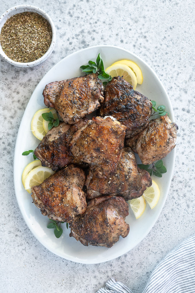 Platter of grilled chicken thighs with lemon, oregano and za'atar seasoning