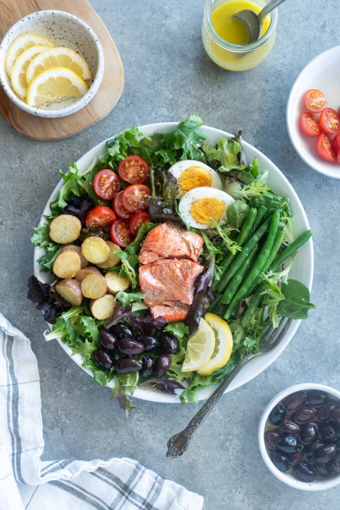 Salmon nicoise salad with ingredients surrounding