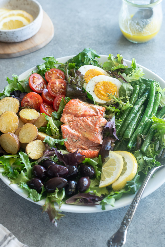 Salad nicoise with salmon on a white plate