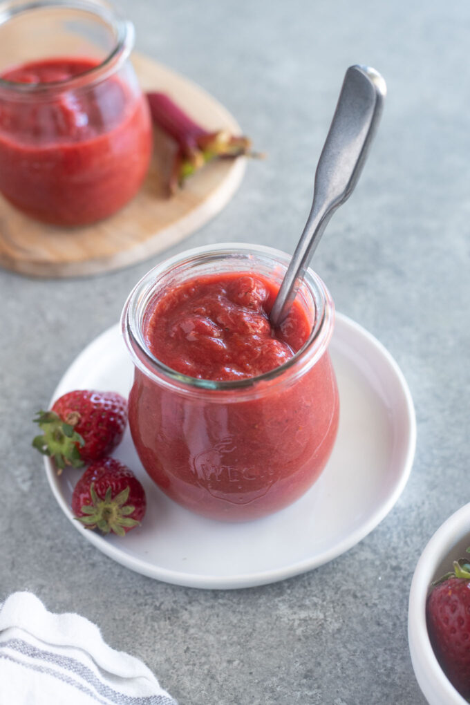 Strawberry Rhubarb Jam in a jar with spoon buried inside