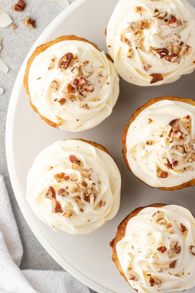 Platter of frosted hummingbird cupcakes garnished with toasted pecans