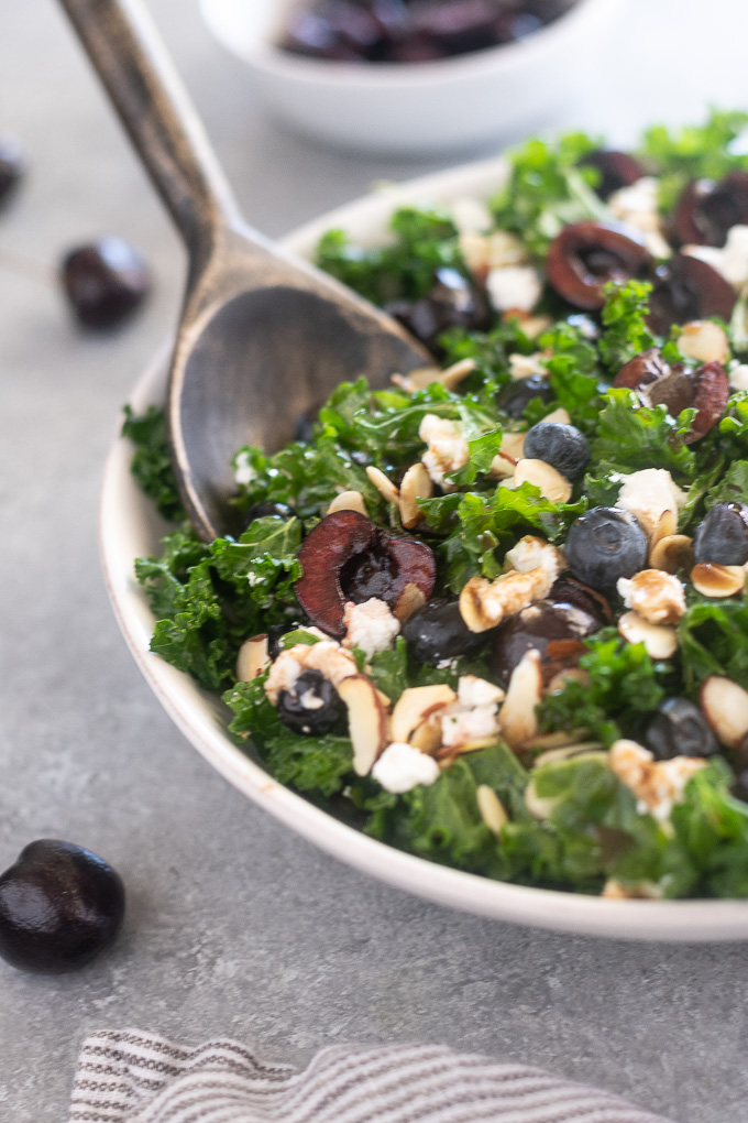 Summer kale salad in a bowl with servers
