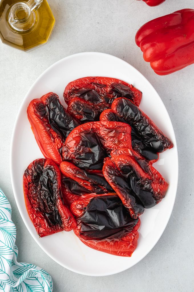 Charred roasted red peppers on a platter