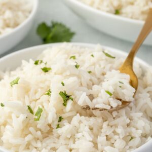 Coconut rice in a bowl with a fork digging in