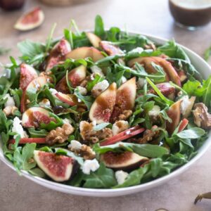Fig salad in a white bowl with dressing