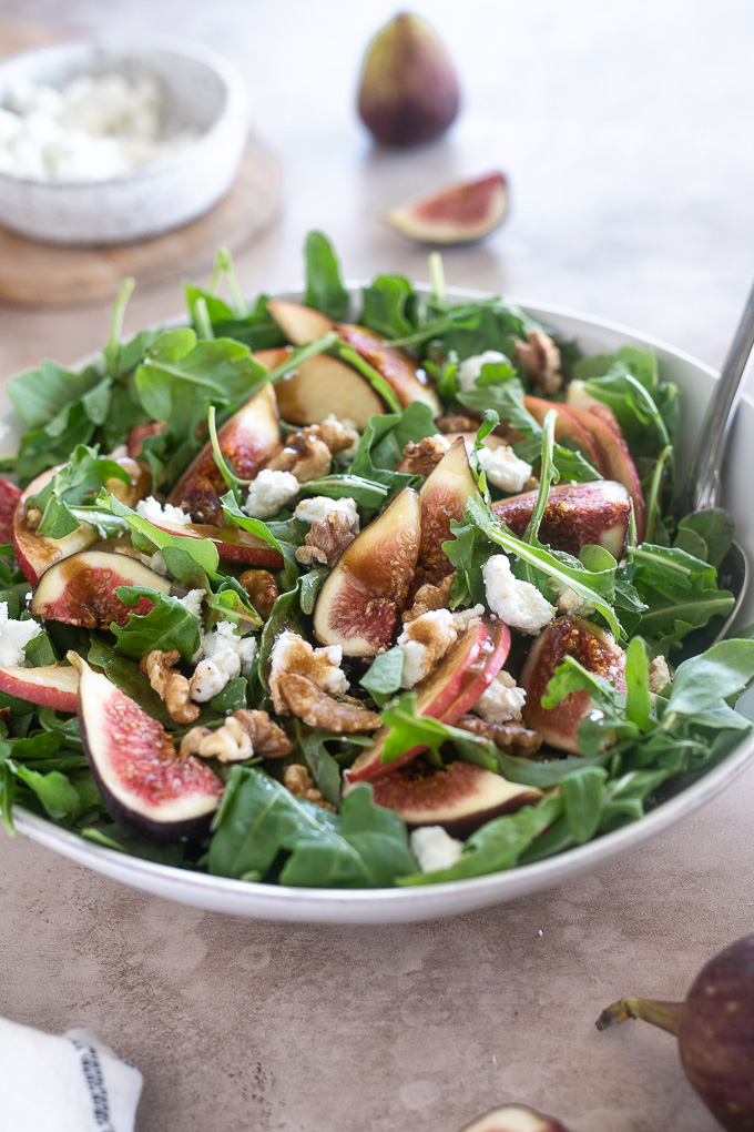 Arugula fig salad with balsamic dressing drizzled over it
