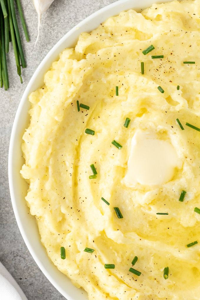 Yukon mashed potatoes in a bowl with butter and chopped chives
