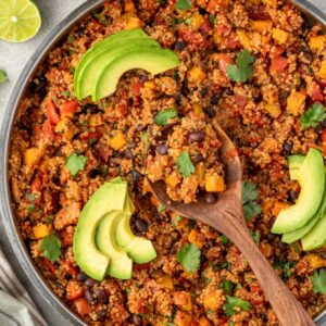 Mexican quinoa in a pan with wooden spoon in center