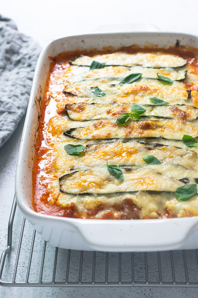 Keto zucchini lasagna in baking dish with basil on top