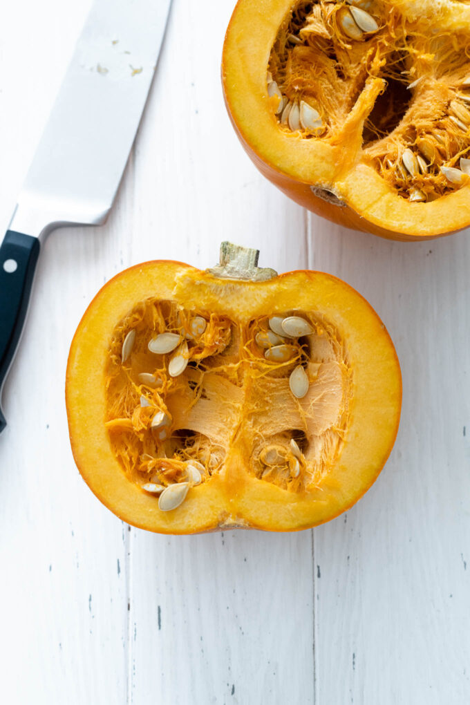 Halved pumpkin with knife nearby
