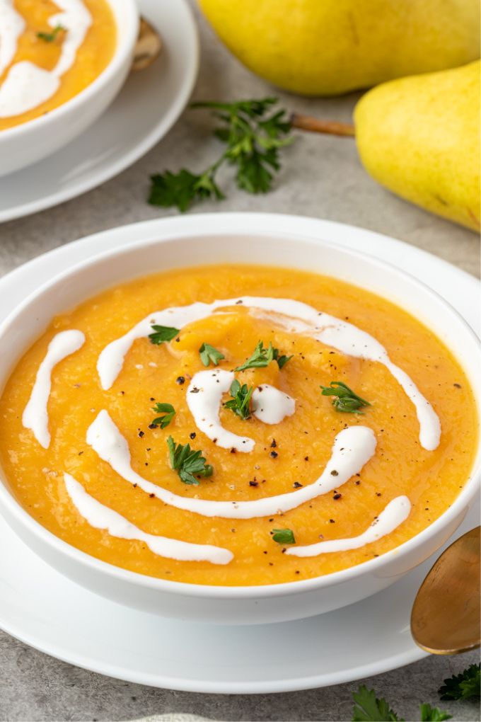 Roasted butternut squash and pear soup in a bowl with coconut milk