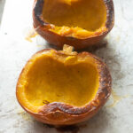 Whole roasted pumpkin on a baking sheet