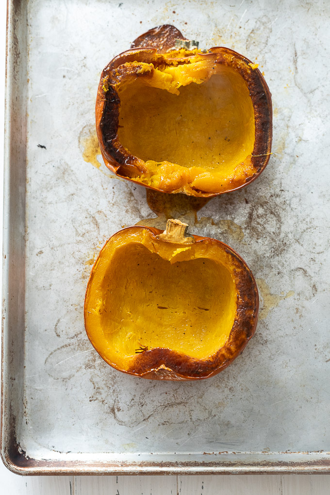 Roasted pumpkin halves on a baking sheet