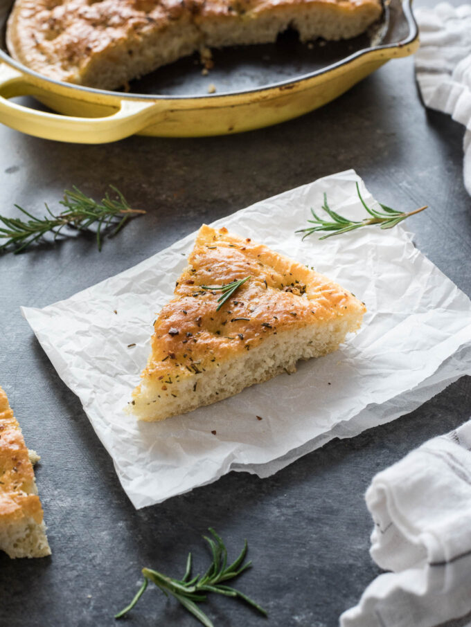 Slice of rosemary focaccia bread on parchment paper