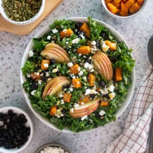 fall harvest salad in a bowl with toppings alongside