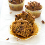 Pumpkin oat flour muffins with front muffin cut in half.