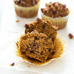 Pumpkin oat flour muffins with front muffin cut in half.