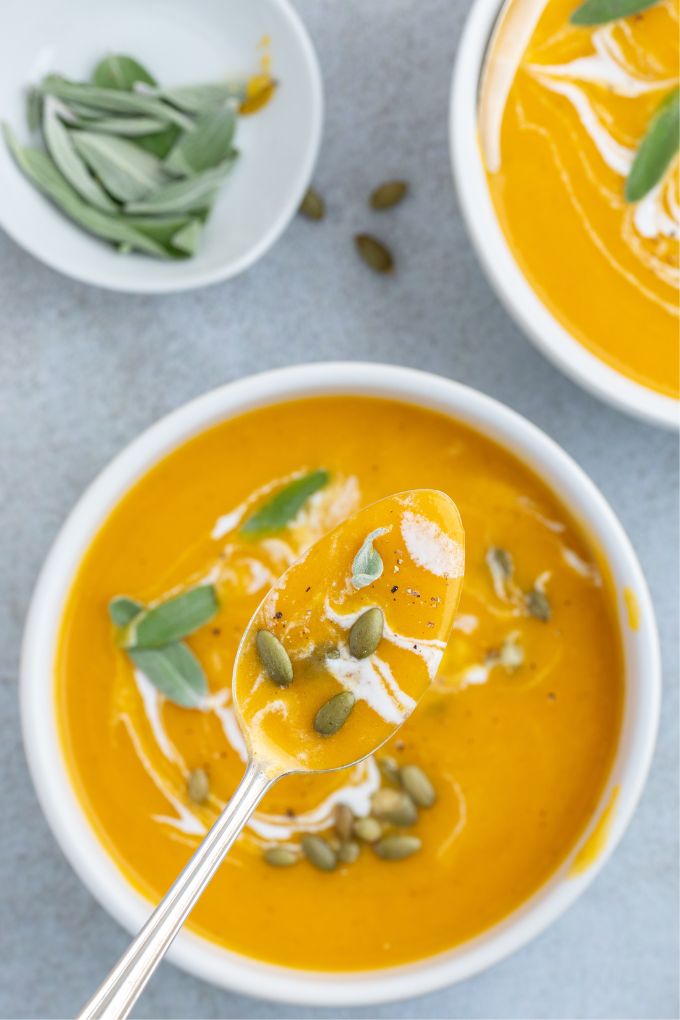 Spoonful of roasted pumpkin apple soup over the bowl
