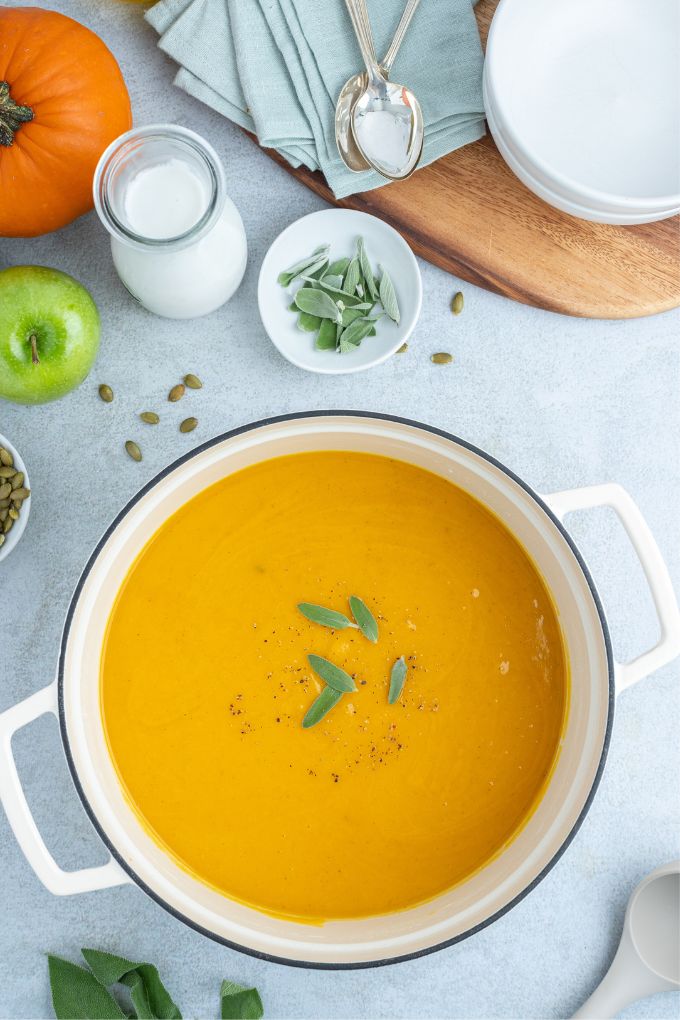 Pot of roasted pumpkin apple soup with sage on top