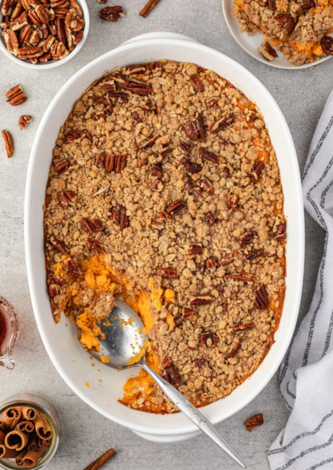 Spoon digging into sweet potato casserole with streusel topping