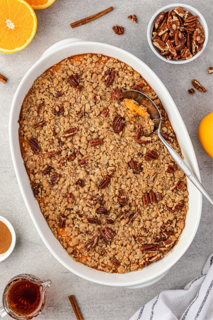 Sweet potato casserole in baking dish with a serving spoon