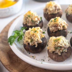 Sausage stuffed mushrooms on a plate with parsley