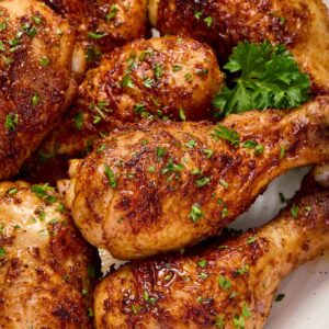 Air fryer chicken drumsticks on a plate with parsley