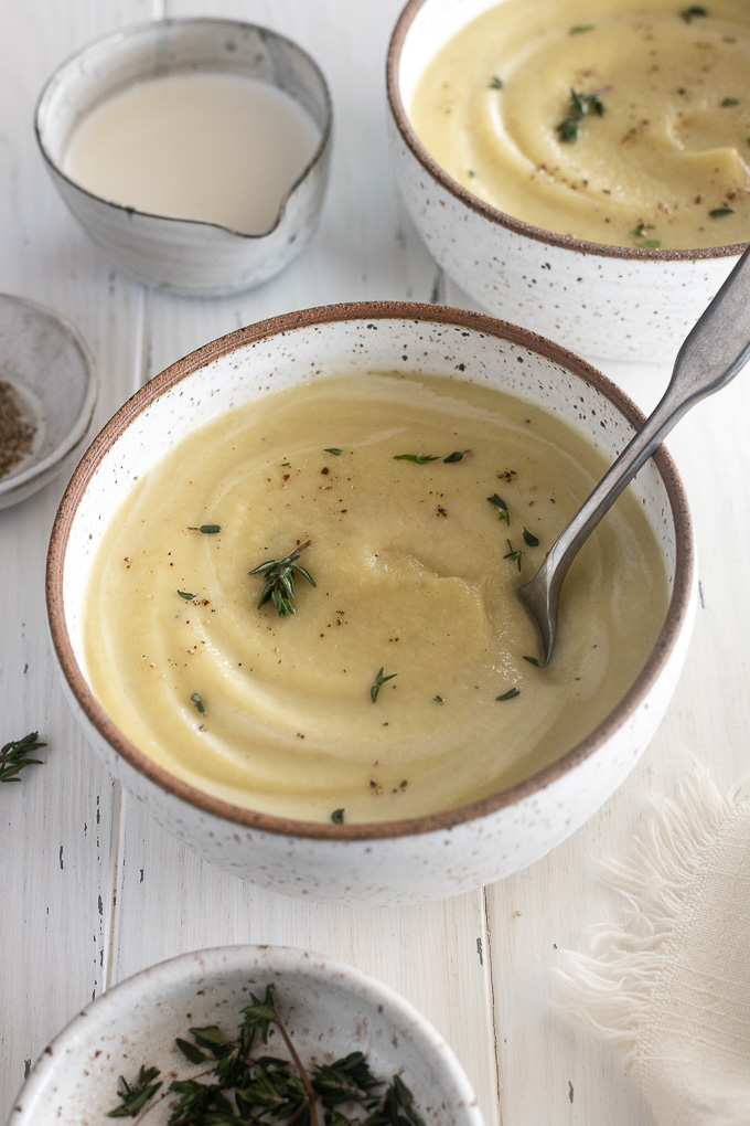 Bowl of creamy parsnip soup with a spoon buried inside