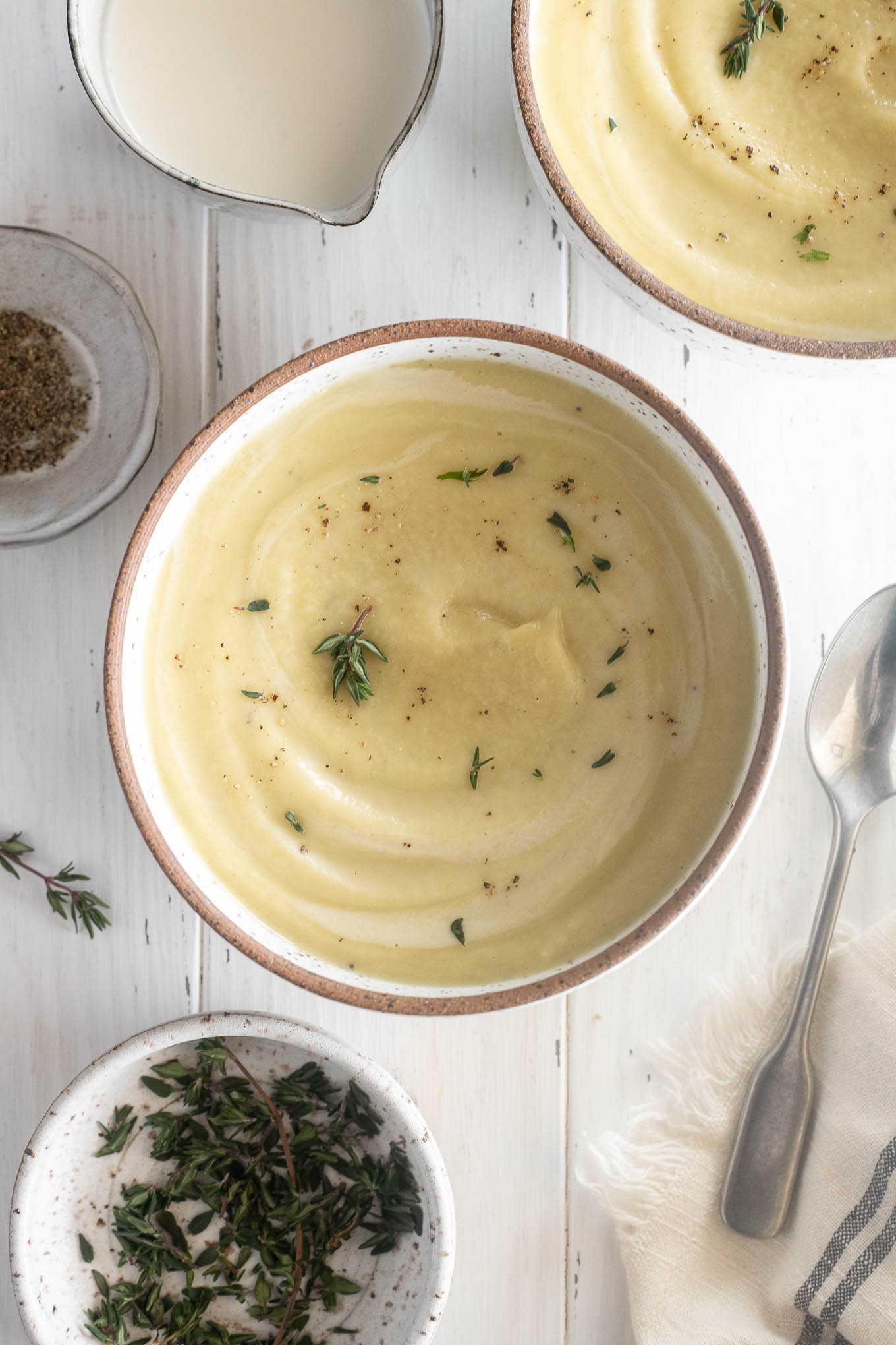 Parsnip soup in a bowl with thyme leaves