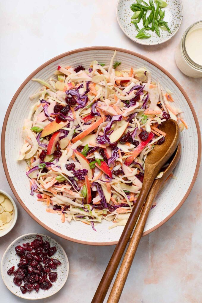 Apple fennel slaw in a bowl with wooden servers