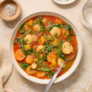 Instant pot vegetable soup in a bowl with parsley and pepper.