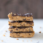 Stack of no bake peanut butter bars with cacao nibs.