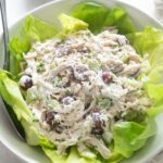 Sonoma chicken salad in a bowl over a bed of lettuce.