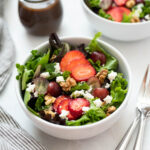 Strawberry feta salad in a white bowl.