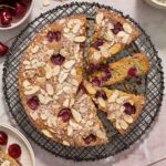 Cherry almond cake sliced on a wire rack.