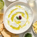 Greek tzatziki in a bowl with olive oil and dill.