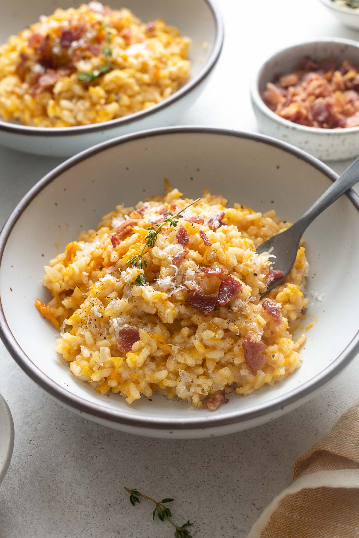 Pumpkin risotto in a bowl with fork digging in.