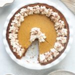 Pumpkin cheesecake pie with a slice cut out.