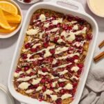 Baked cranberry oatmeal with orange glaze in baking dish.