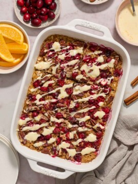 Baked cranberry oatmeal with orange glaze in baking dish.