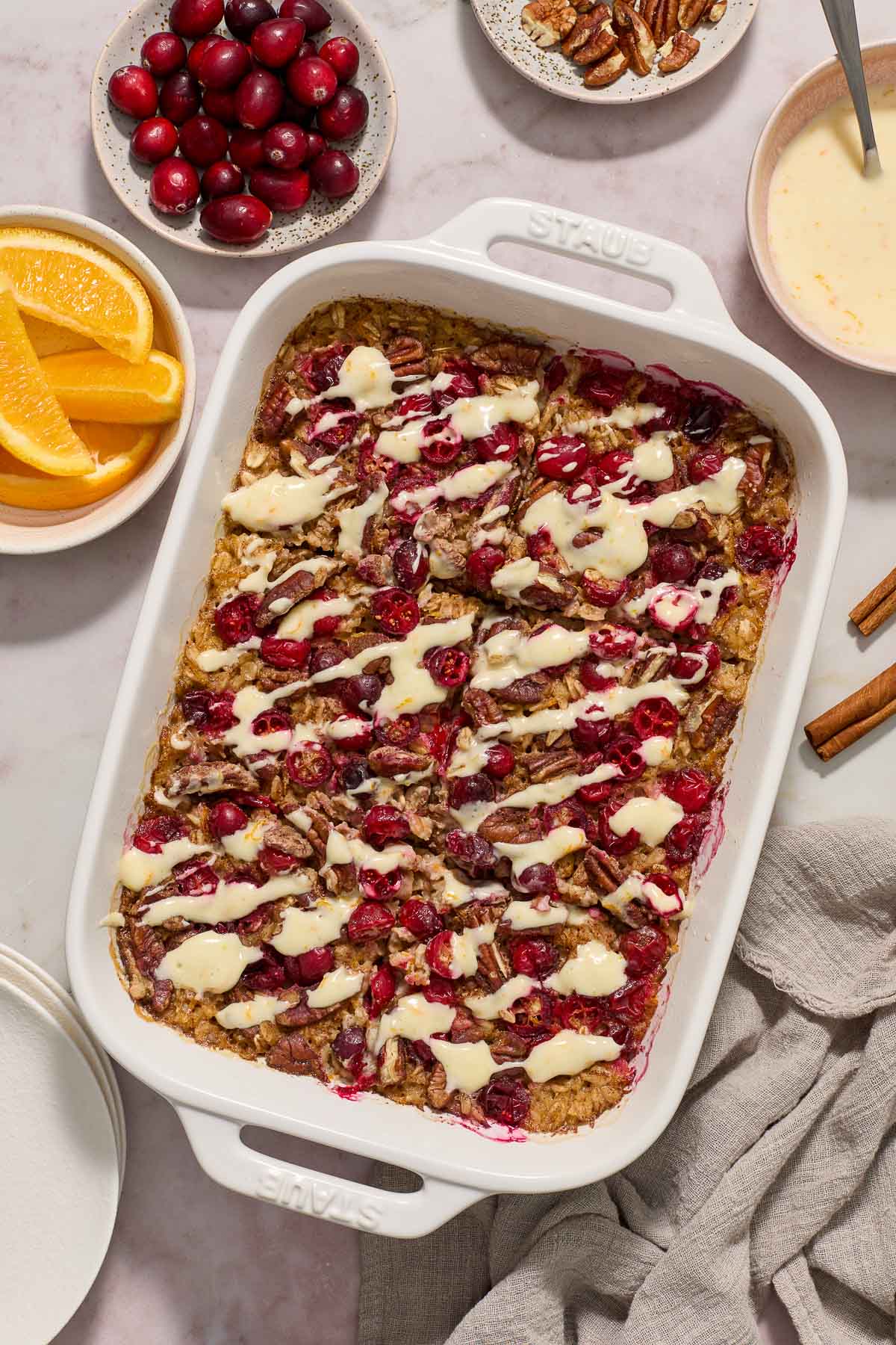 Baked cranberry oatmeal with orange glaze in baking dish.