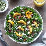Delicata squash salad in a bowl with dressing alongside.