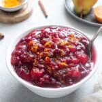 Port cranberry sauce in a bowl with a spoon.