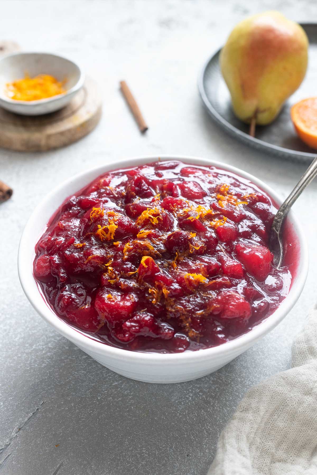 Port cranberry sauce in a bowl with a spoon.