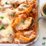 Serving spoon with stuffed shells with ground beef.